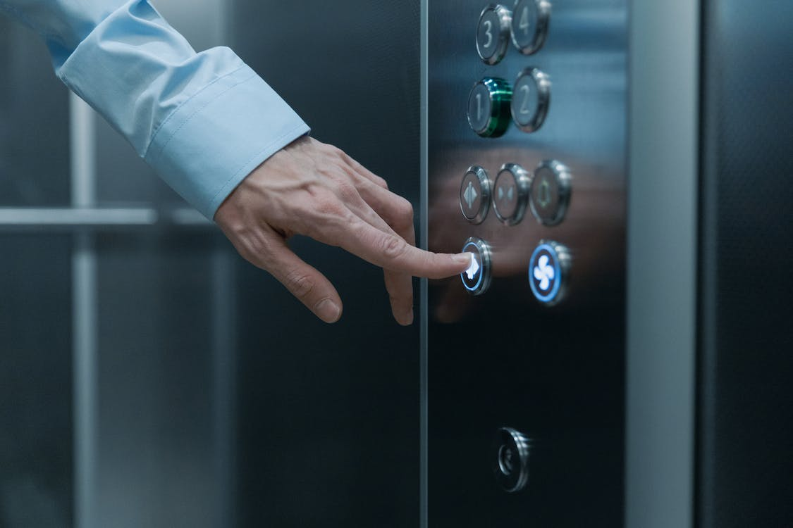 A person is pressing elevator buttons