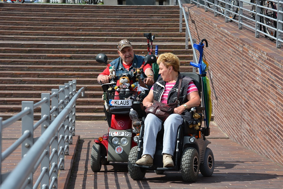 Couple entering a building through a ramp for wheelchairs